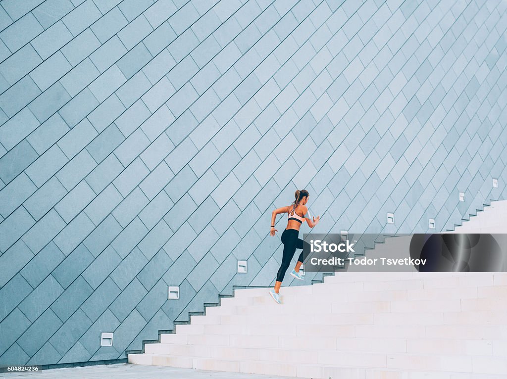 Running Up The Stairs Woman exercising on a staircase outside in the  city. Staircase Stock Photo