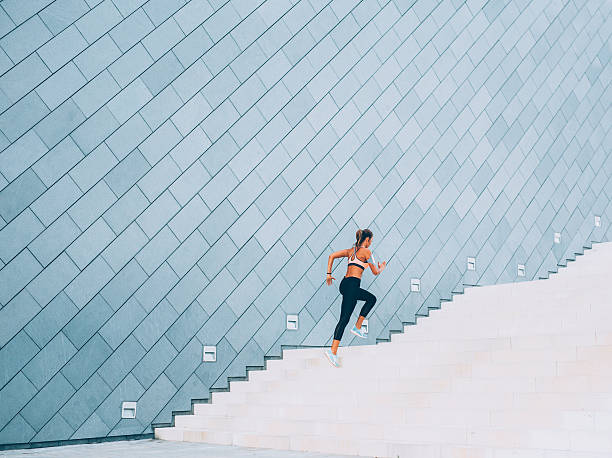 Running Up The Stairs Woman exercising on a staircase outside in the  city. climbing staircase stock pictures, royalty-free photos & images