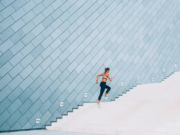 Woman exercising on a staircase outside in the  city.