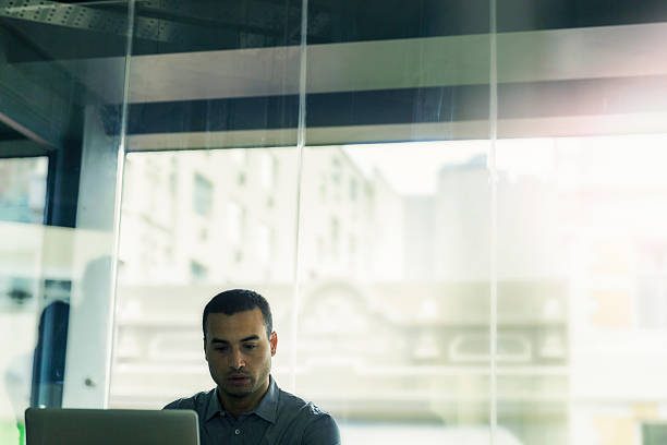 istock Mid adult businessman using laptop in office 604824594