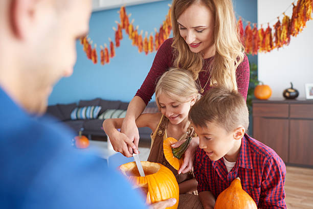 istock Family working on Halloween pumpkins 604827194