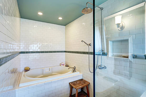 istock Blue bathroom interior with white tile trim wall, glass shower 604828404