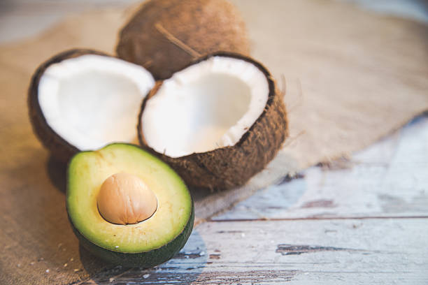Cracked coconut with avocado over white background
