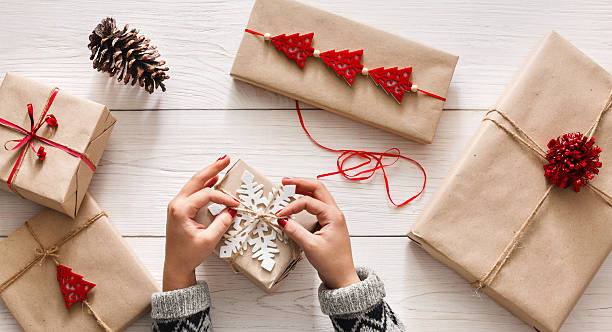 istock Woman's hands wrapping christmas holiday present with craft twine 604862954