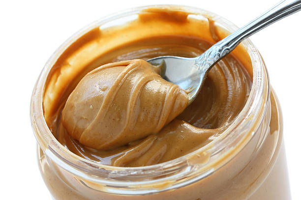 istock open jar of peanut butter with spoon 604863902