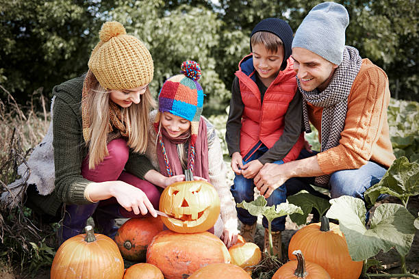 istock Parents with child preparing to pumpkin for Halloween 604864958