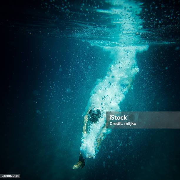 Underwater Action Shot Of Diver Breaking Water Surface Stock Photo - Download Image Now