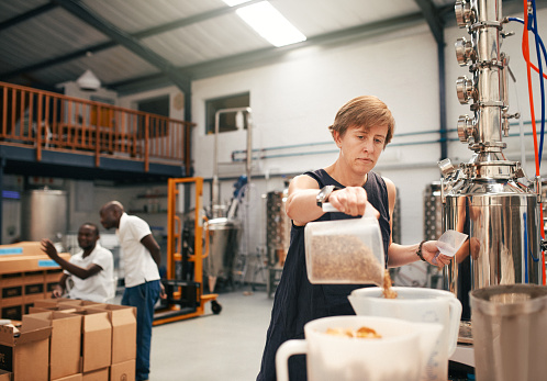 Shot of a woman working with barley at a distillery