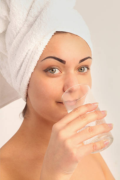 istock woman in a towel drinking spring water 604890946