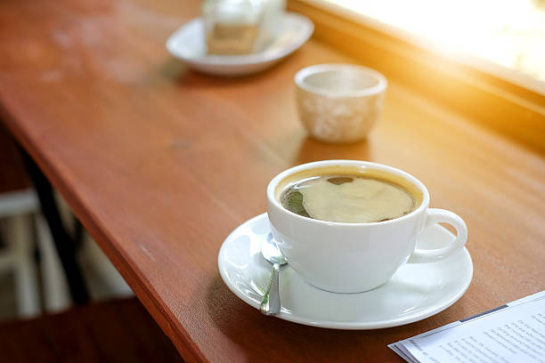 istock White coffee cup on wooden floor. 604893534