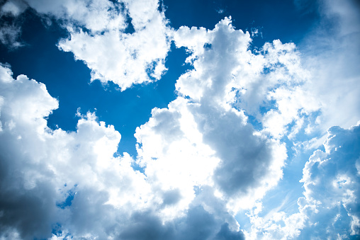 Photo of white puffy clouds in the blue sky.