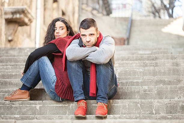 istock Young couple having relationship difficulties and sitting on stairs 604897548