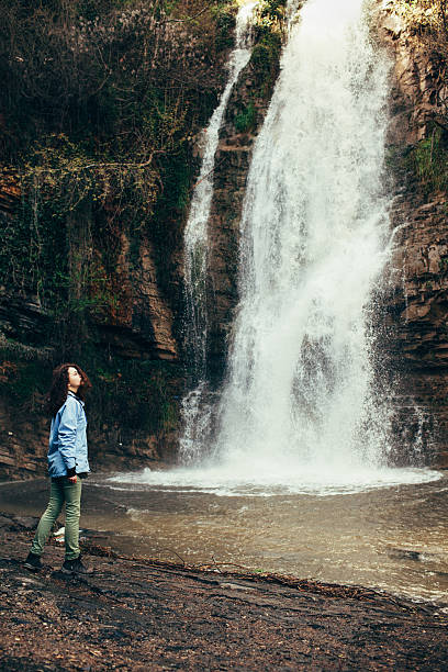 istock Girl near the waterfall 604903178
