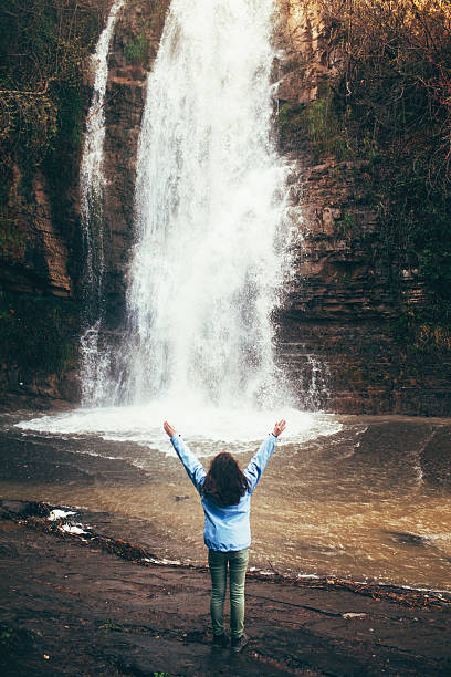istock Girl near the waterfall 604903234