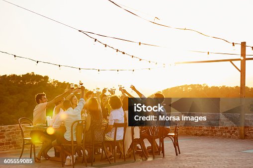istock Friends toasting drinks during social gathering 605559085