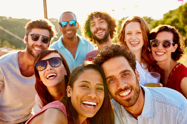 Friends smiling together during summer vacation Portrait of multi ethnic friends smiling together during summer vacation organized group photos stock pictures, royalty-free photos & images