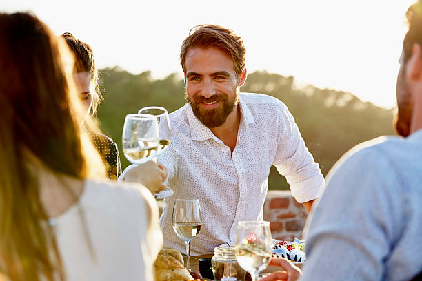 man toasting wineglass with friend - wine glass white wine wineglass imagens e fotografias de stock