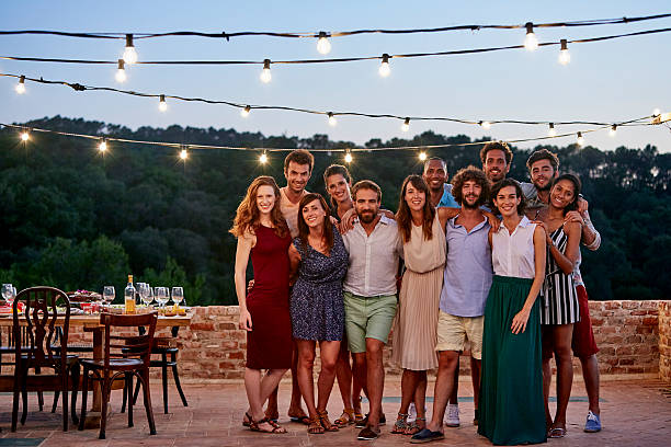 Happy friends standing at patio during gathering Full length portrait of happy friends standing together at patio during social gathering organized group photos stock pictures, royalty-free photos & images