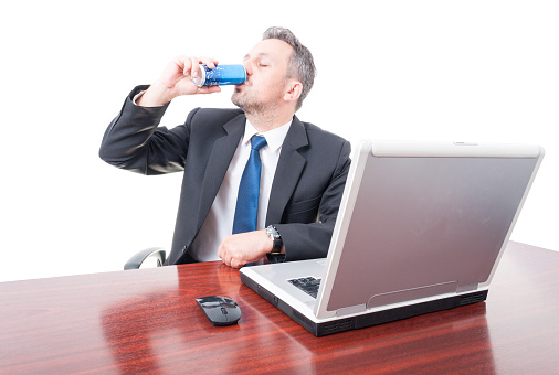 Man wearing suit at office drinking energy drink isolated on white background