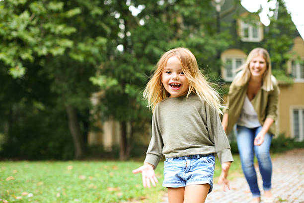 Mother chasing girl outdoor.