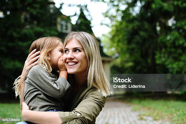 Hija Susurrando Al Oído De Las Madres Foto de stock y más banco de imágenes de Niño - Niño, Familia, Madre