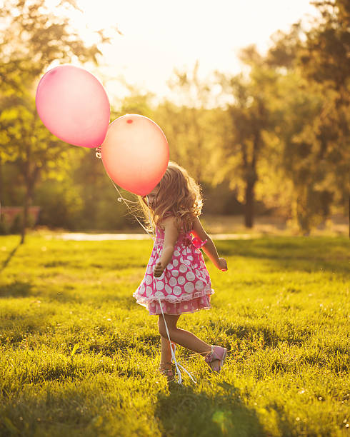 istock Little girl with balloons 605742908