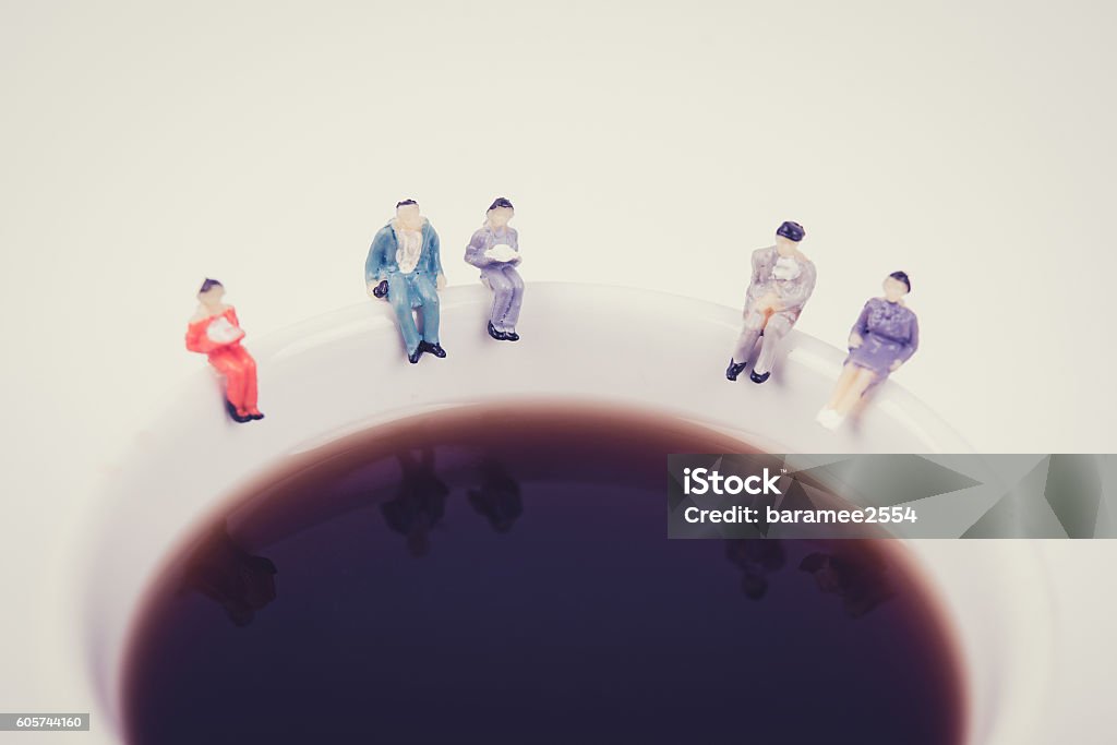équipe d’affaires de personnes miniatures assise sur une tasse de café blanc - Photo de De petite taille libre de droits