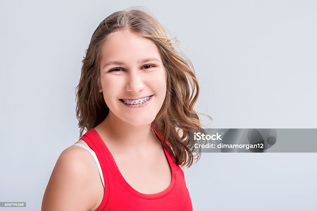 Smiling Caucasian Young Blond Teenage Girl With Teeth Bracket System Dental and Medical Concept. Smiling Caucasian Young Blond Teenage Girl With Teeth Bracket System. Against White Background.Horizontal Image Teenage Girls Stock Photo