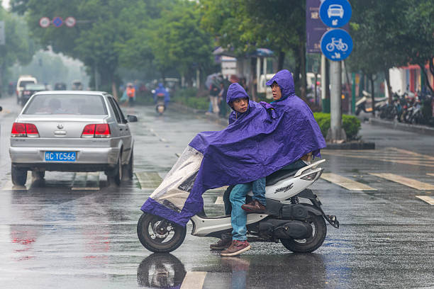 During the rainy season, The motorcycle riders are waiting for the traffic light in the street of Kaohsiung City, Taiwan.