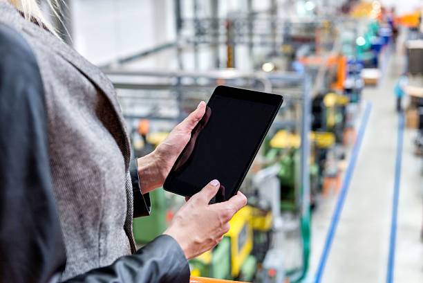istock Working with tablet in large production line 605750234