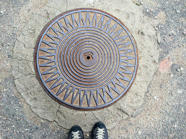 Women legs standing at iron hatch on pavement street Women legs standing at iron hatch on pavement street sewer lid stock pictures, royalty-free photos & images