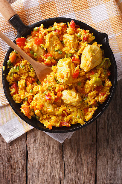 Hispanic cuisine: Arroz con pollo in pan. vertical top view