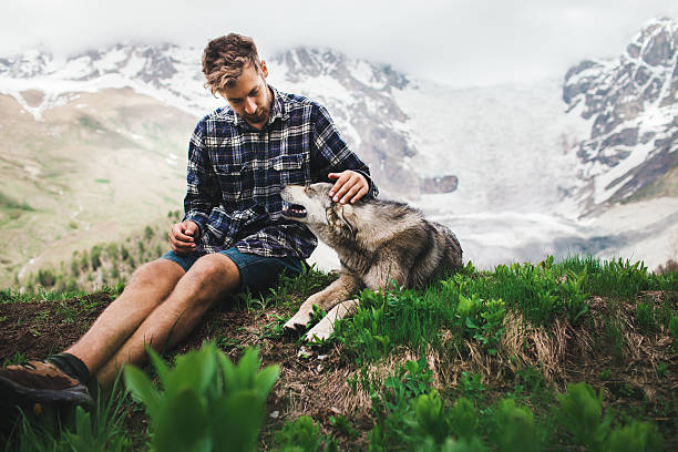 istock Man with dog in mountains 605756444