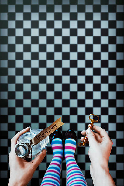 Alice in wonderland. Background Alice in wonderland. Background. A key and a potion in hands against a  chess floor chess board photos stock pictures, royalty-free photos & images