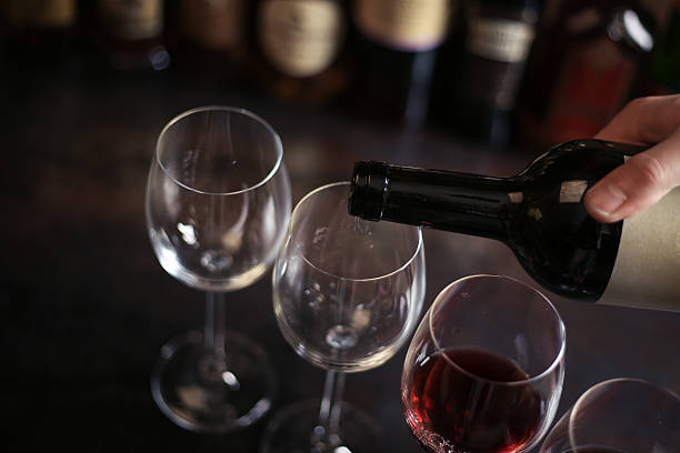 barista versa un bicchiere di vino rosso - glass bar relaxation red foto e immagini stock