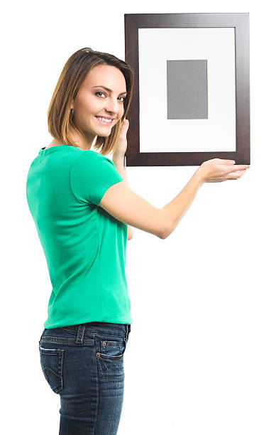 istock Woman hanging picture on white 605762774