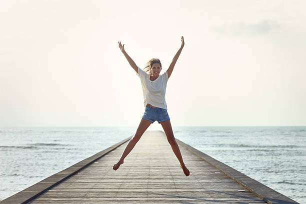 istock Happy jumping girl on the pier 605763196
