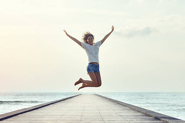 istock Happy jumping girl on the pier 605763274