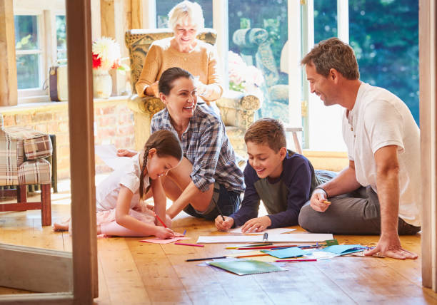 Family coloring on floor in sun room  leanincollection stock pictures, royalty-free photos & images