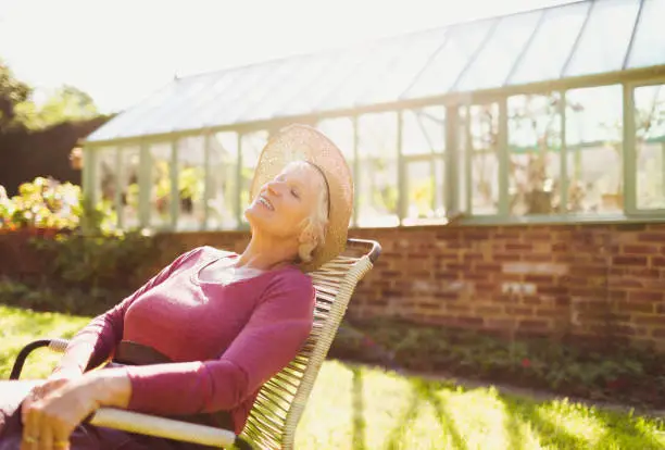 Photo of Carefree senior woman relaxing outside sunny greenhouse