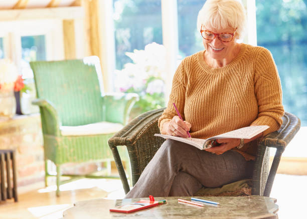 istock Senior woman coloring in coloring book 605763707