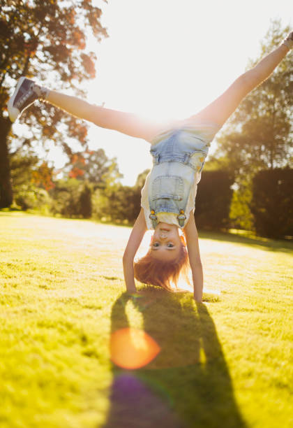 istock Girl doing handstand in sunny garden 605763833