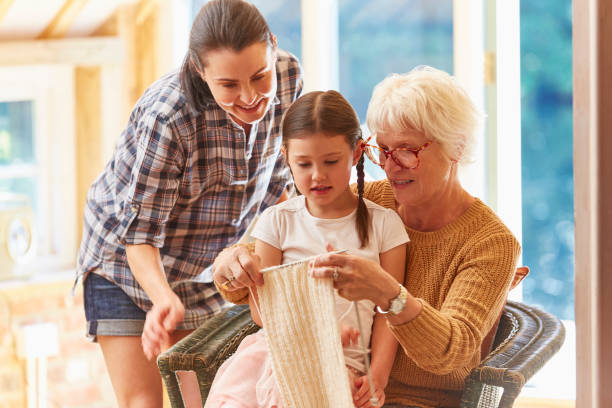 A senior woman and her granddaughter working together in their cozy home studio