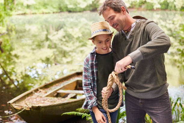 Father teaching son how to tie a rope knot  9 stock pictures, royalty-free photos & images