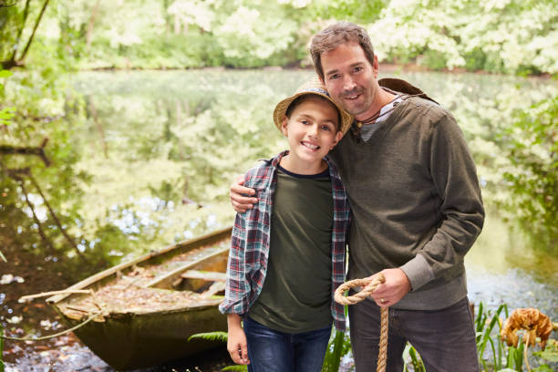 istock Portrait father and son with boat at pond 605763967