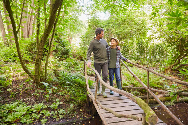 istock Father and son crossing footbridge in forest 605764107