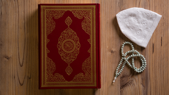 The Holy Book Koran and prayer beads on the floor horizontal indoors shot.