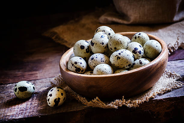 Quail eggs in a bowl Quail eggs in a bowl, vintage wooden background, rustic style. Low key, selective focus quail egg stock pictures, royalty-free photos & images