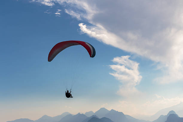 istock Parachute and human silhouette. Blu sky adventure. 605768964