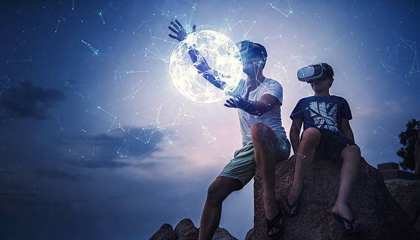 istock Father and son using Virtual Reality glasses sitting outside 605768966
